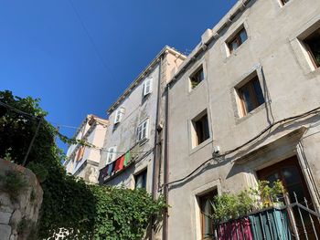 Low angle view of buildings against clear blue sky