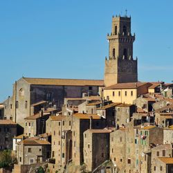 Buildings in pitigliano city against clear blue sky