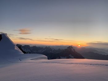 Scenic view of snow covered mountains against sky during sunset