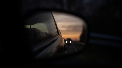 Close-up of side-view mirror with following car