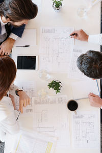 Directly above shot of people working on desk at office