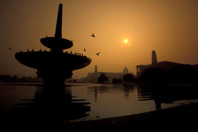 Silhouette of fountain against sky during sunset