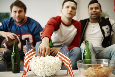 Friends eating snacks while sitting at home