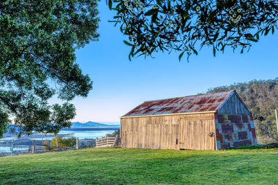 Barn on field against clear sky