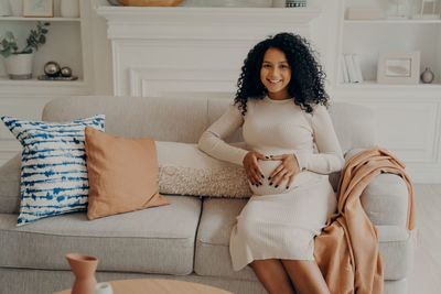 Portrait of woman sitting on sofa at home