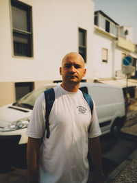 Portrait of bald mid adult man standing in city