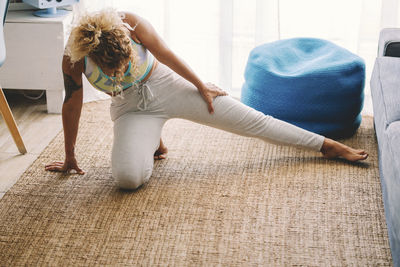 Full length of woman exercising at home