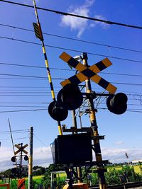 Low angle view of power lines against blue sky