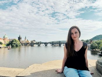 Portrait of woman sitting against river