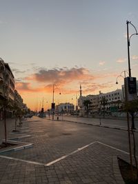 City street against sky during sunset