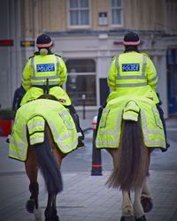 Rear view of police officers on horse outdoors