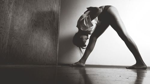 Side view of woman bending at home