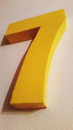 High angle view of yellow paper on table against wall