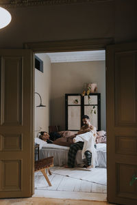 Couple in bedroom seen through doorway at home