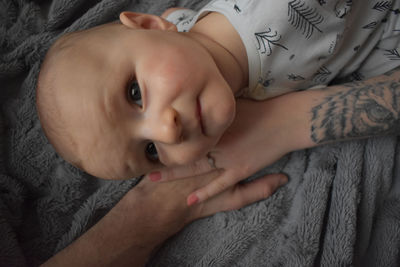 Portrait of cute baby lying on bed at home