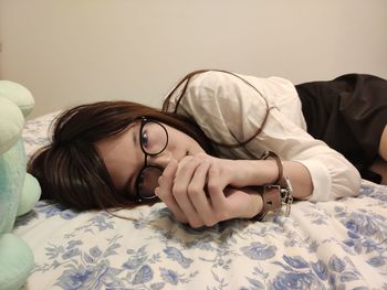 Young woman lying down on bed