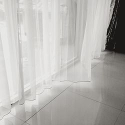 White curtain hanging on floor at home