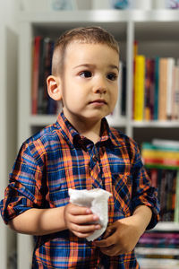 Close-up of boy looking away standing at home