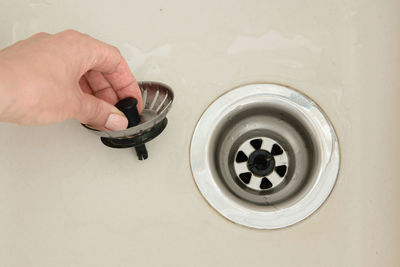 Close-up of woman holding drain of sink