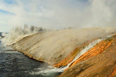 Scenic view of hot spring against sky