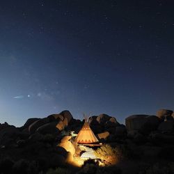 Illuminated castle against sky at night