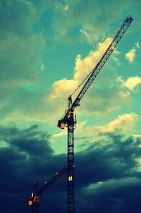 Low angle view of crane against cloudy sky