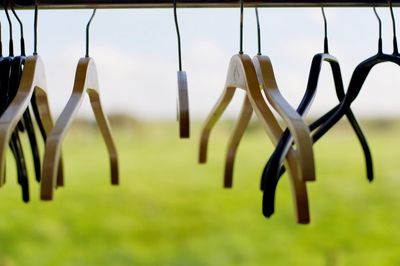 Close-up of coathangers with field in background