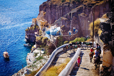 High angle view of people riding donkey on staircase at santorini