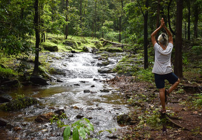 Rear view of woman standing in forest