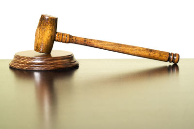 High angle view of gavel on wooden table against white background