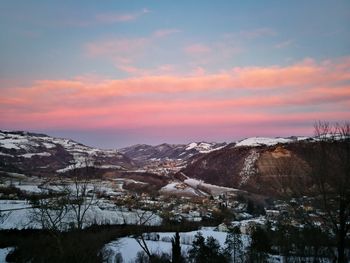 Scenic view of snowcapped mountains against sky during sunset