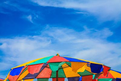 Low angle view of umbrellas on beach against sky