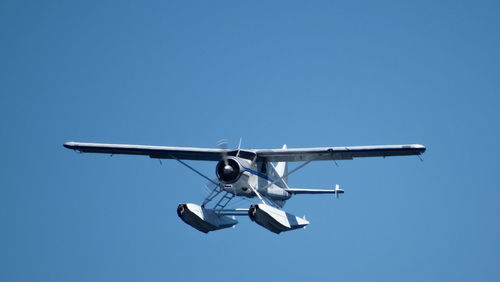 Low angle view of seaplane flying against clear sky
