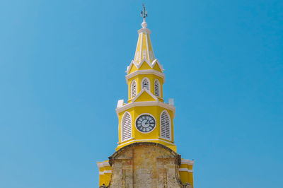 Low angle view of church clock tower against clear blue sky