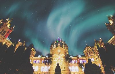 Low angle view of illuminated buildings against sky at night