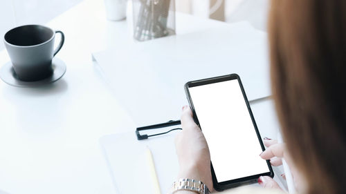 Low angle view of woman using mobile phone on table