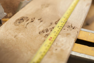 Close-up of measuring tape on wooden plank