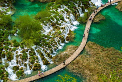 High angle view of people walking on boardwalk over water at plitvice lakes national park