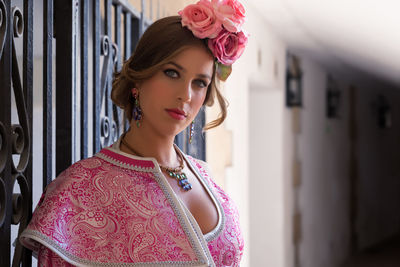 Portrait of beautiful woman standing against wall