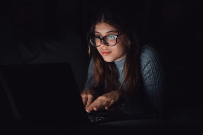 Portrait of young woman using laptop at home