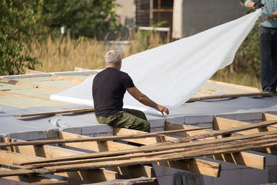 Rear view of man working on wood