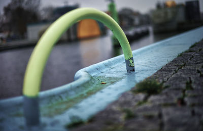 Close-up of wet metal railing by street