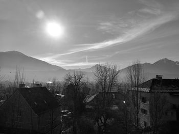 Houses and trees against sky in city