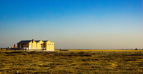 Building on field against clear sky