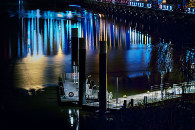 Blurred motion of illuminated bridge over lake in city at night