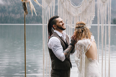 Side view of young couple standing in water