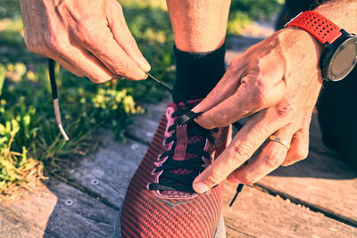 Close-up of man holding hands on field