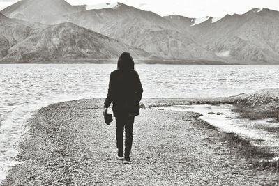 Rear view of two people standing on lake