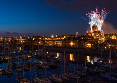 Firework display, harbor, and illuminated city at night