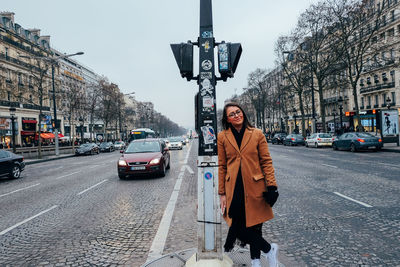 Woman with umbrella walking on street in city